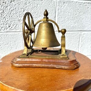vintage brass ship's bell mounted on a wooden base